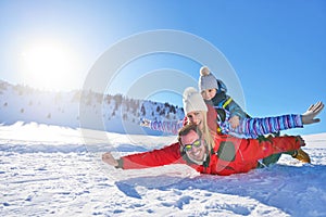 Happy young family playing in fresh snow at beautiful sunny winter day outdoor in nature