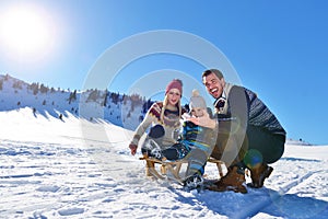 Happy young family playing in fresh snow at beautiful sunny winter day outdoor in nature