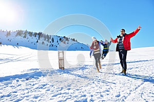 Happy young family playing in fresh snow at beautiful sunny winter day outdoor in nature
