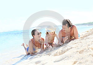 Happy young family playing on a sandy beach