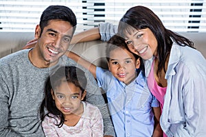 Happy young family posing together on the couch