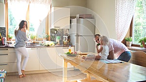 Happy young family preparing breakfast in the kitchen.