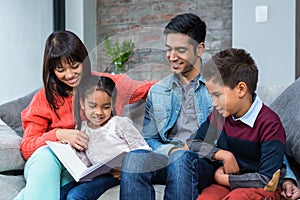 Happy young family reading a book together