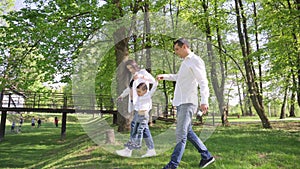 A happy young family is resting in the park. A wife with her husband and child relaxing in nature