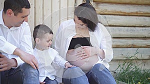 A happy young family is resting in the park. A wife with her husband and child relaxing in nature