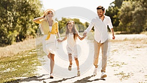 Happy young family running in countryside, panorama