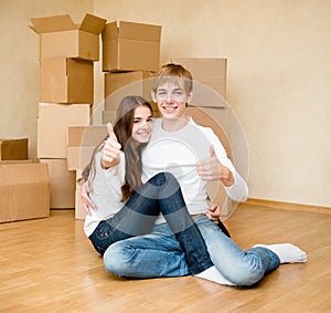 Happy young family showing thumbs up on a background of cardboard