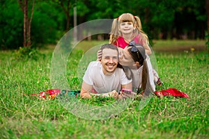 Happy young family spending time outdoor on summer day. Happiness and harmony in family life