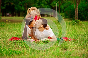 Happy young family spending time outdoor on summer day. Happiness and harmony in family life.