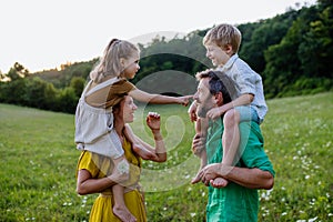 Happy young family spending time together outside in green nature.