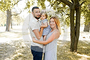 Happy young family spending time together outside in green nature. Parents, childhood, child, care, daughter, father, mother