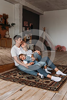 A happy young family spends time together in a home interior. A beautiful happy family spending time together at home.