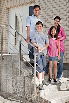 Happy young family standing at doorstep