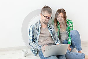 Happy young family surfs Internet in search of online stores of furniture and accessories for an apartment with the help