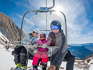 Happy young family taking a selfie on ski lift at a rest.