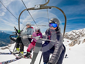 Happy young family taking a selfie on ski lift at a rest.