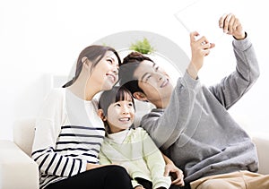 Happy young family taking selfies on sofa photo