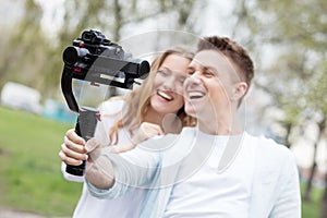 Happy young family taking video selfies with her camera on the gimbal steadycam photo