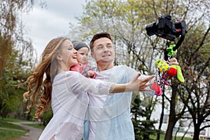 Happy young family taking video selfies with her camera on the gimbal steadycam photo