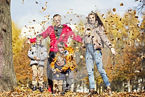 Happy young family with three children in the autumn park. Love and tenderness. Walk in the golden season