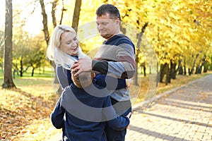 happy young family three people spending time outdoor in the autumn park