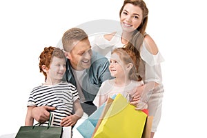 happy young family with two children holding shopping bags