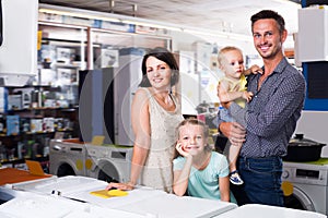 Happy young family with two children shopping