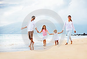 Happy young family walking on the beach