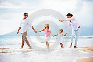 Happy young family walking on the beach