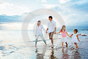 Happy young family walking on the beach photo