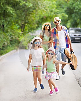 Happy young family walking with guitar spending carefree time to