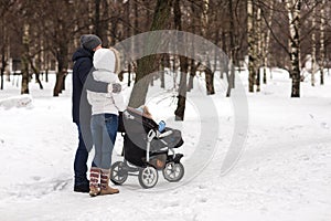 Happy young family walking in the park in winter