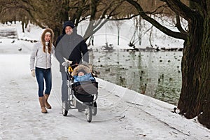 Happy young family walking in the park in winter