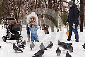 Happy young family walking in the park in winter