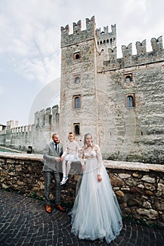 A happy young family walks through the old town of Sirmione in Italy.Stylish family in Italy on a walk