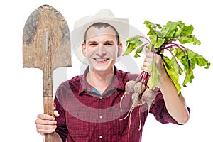 Happy young farmer in a hat with a beet crop on a white