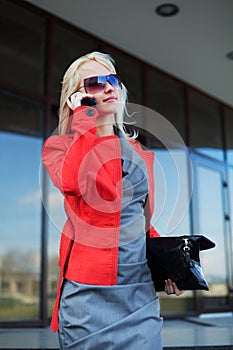 Happy young fashion business woman calling on cell phone