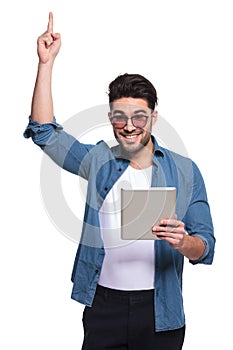Happy young fashion man pointing up