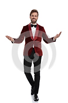 Happy young fashion man wearing red velvet tuxedo