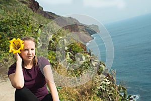 Happy young fashion woman sitting and relaxing on the ocean shore