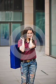 Happy young fashionable woman with bags having a break after shopping