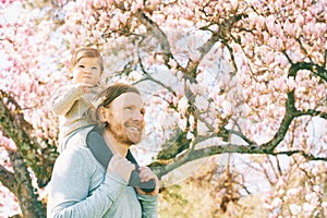 Happy young father carrying child on his shoulders