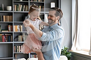 Happy young father dancing with little daughter.