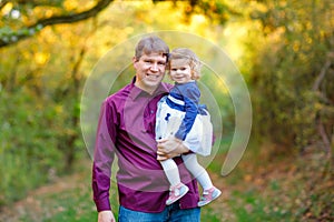 Happy young father having fun cute toddler daughter, family portrait together. man with beautiful baby girl in nature
