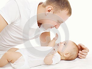 Happy young father with his baby on the bed