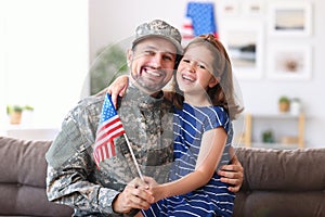 Happy young father in military uniform reunited with cute little daughter at home