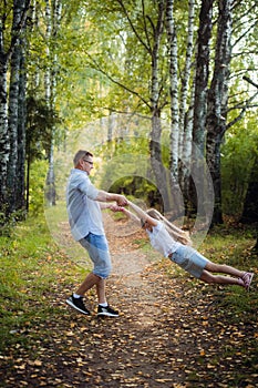 Happy young father playing with child outside in park.