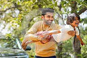 Happy young father playing by holding daughter while kid flying like a plane - concept of emotional well being, weekend