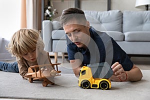 Happy young father playing toys with small kid.