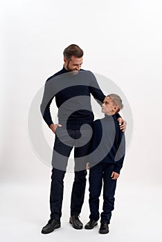 Happy young father and small son pose on white background